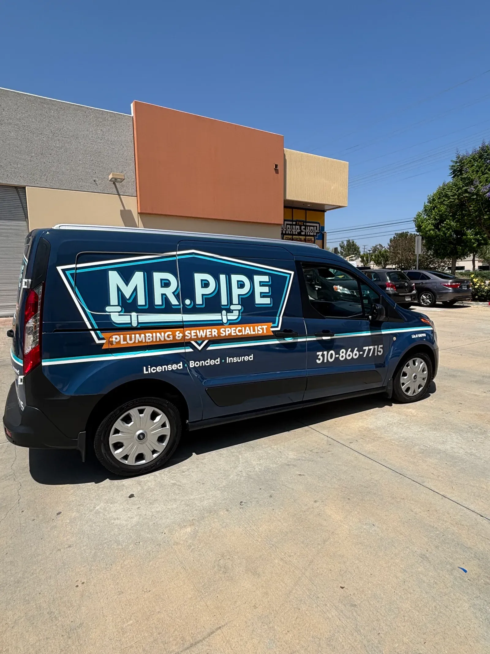 Mr. Pipe Plumbing service van with the license number and phone number on the wrap
